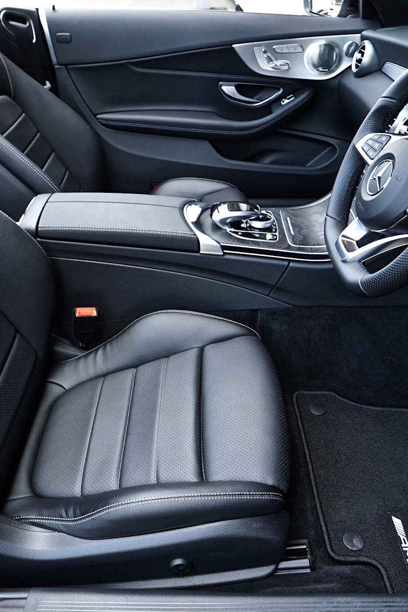Sleek black Mercedes-Benz interior featuring leather seats and modern dashboard design.