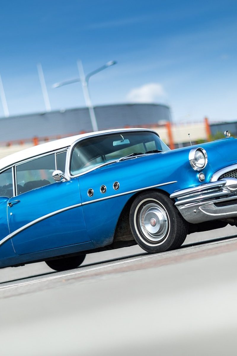 Blue vintage car in motion with restored paint job