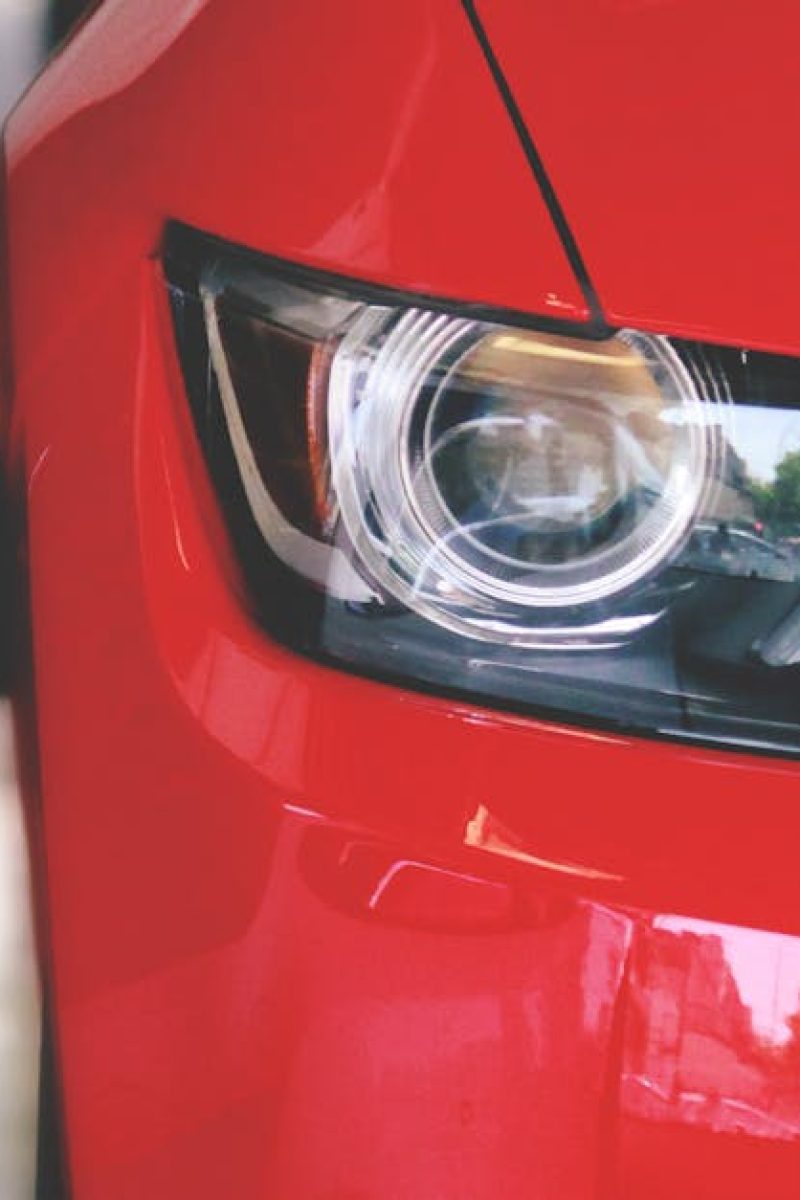 Detailed view of a sleek red sportscar showcasing elegant design and modern headlights.