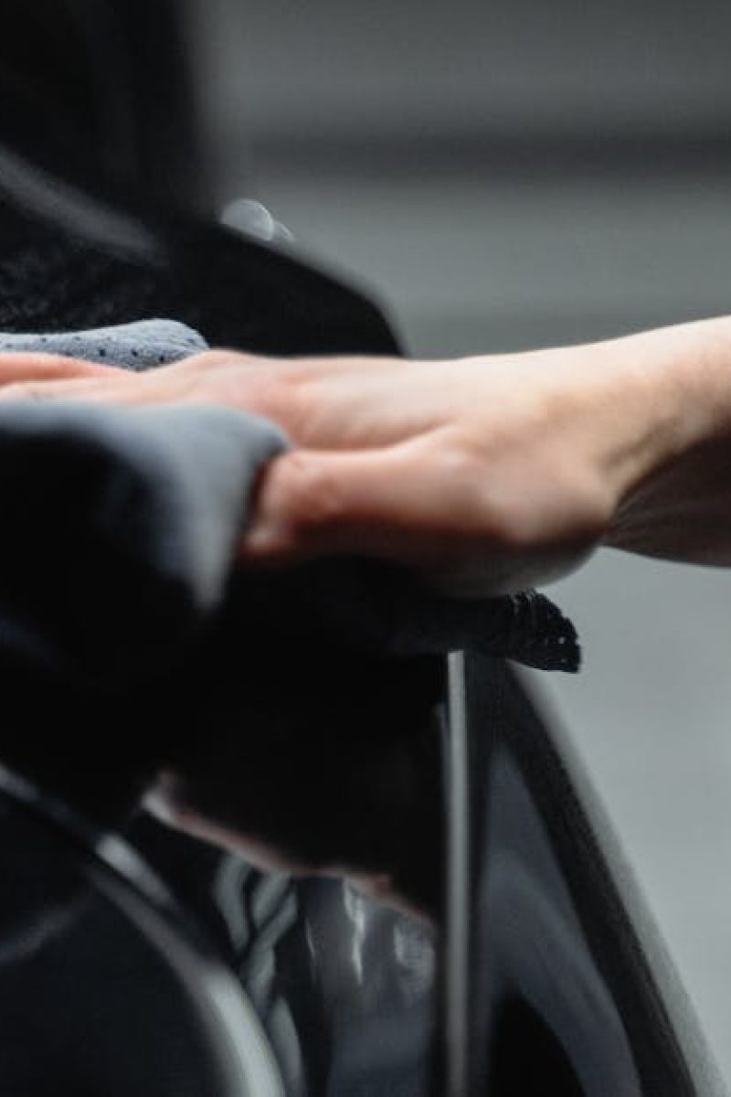 Detailer applying polish to black vehicle exterior